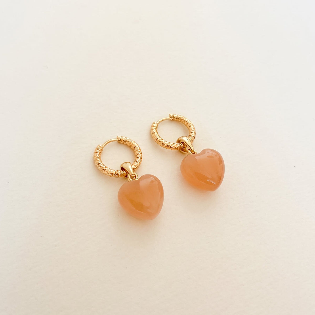 Boucles d'oreilles pierre de soleil cœur bombé — anneaux ciselés